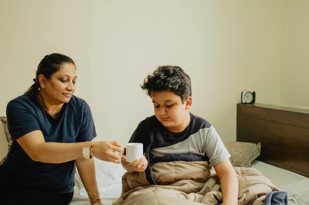 A nurturing mother hands her son a cup in a cozy morning setting.